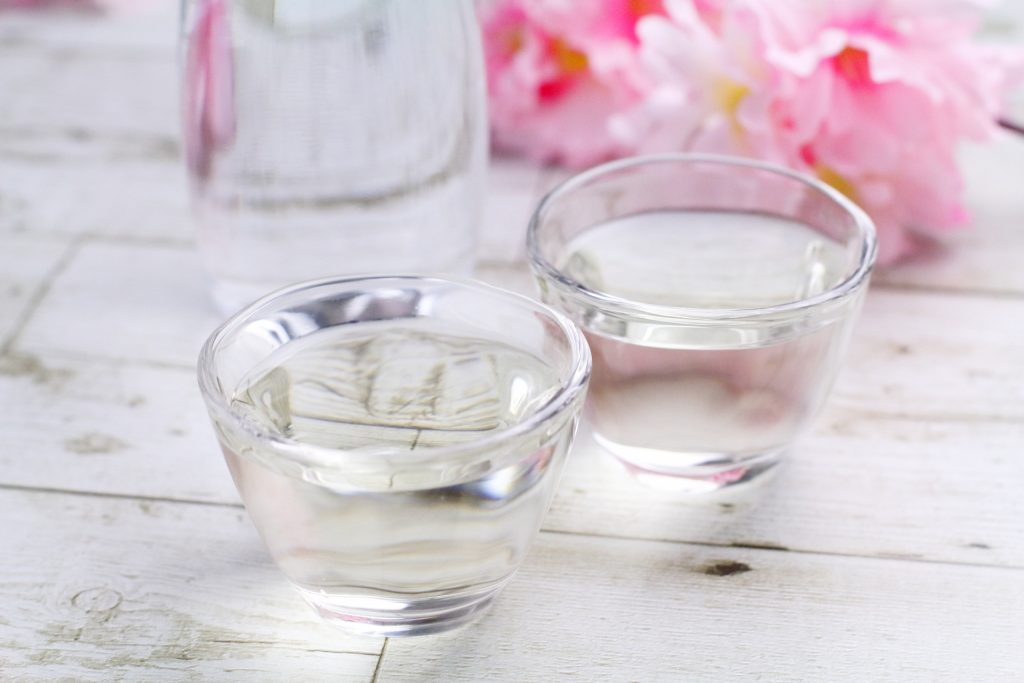 桜と透明な酒器に入った日本酒