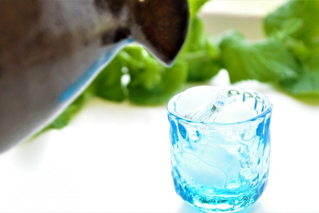 氷の入ったグラスに日本酒を注ぐ様子