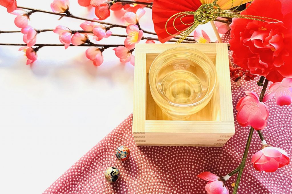 枡に入った日本酒と桃の花